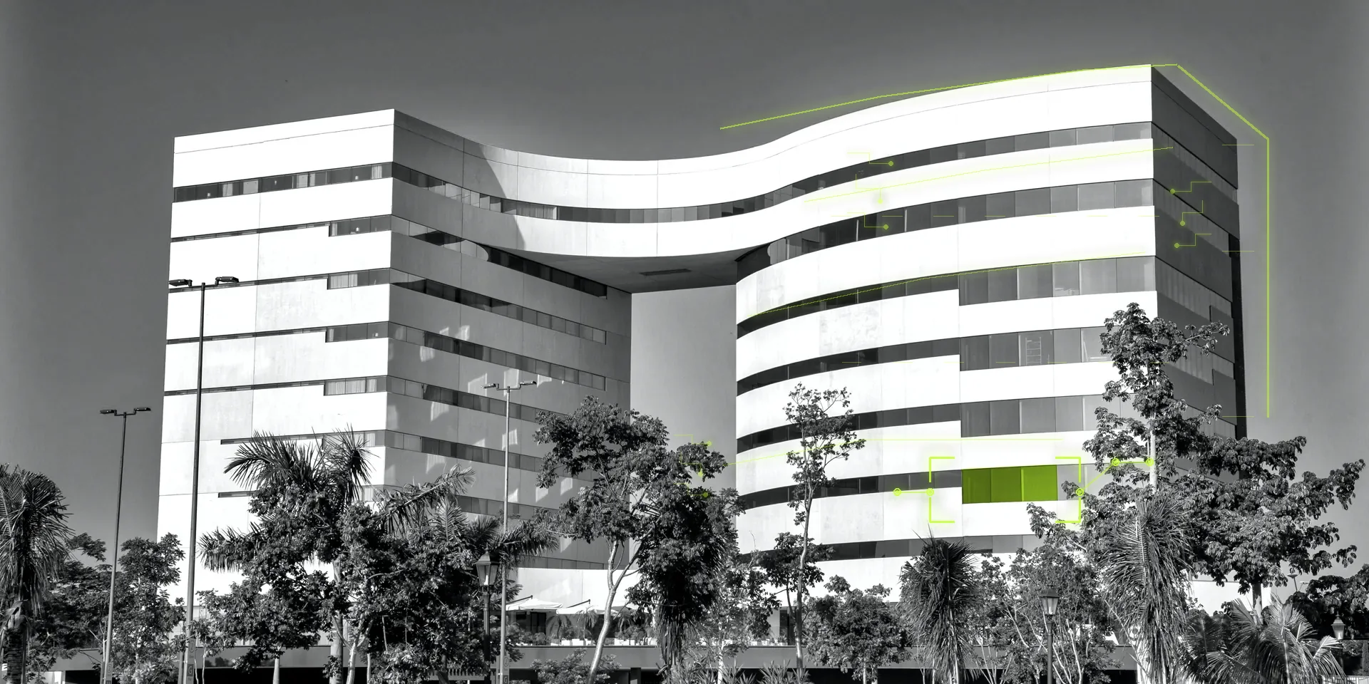 Fachada del edificio de oficinas SkyWork sobre Av. Andrés García Lavín en Mérida, Yucatán, con la oficina de TecnIA Universidad resaltada en verde volt.